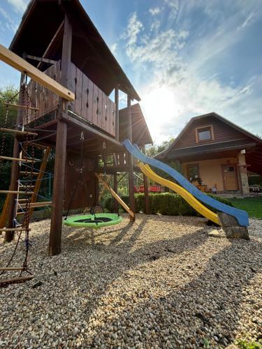 a playground with a slide in front of a house at Country House Liptov in Svätý Kríž