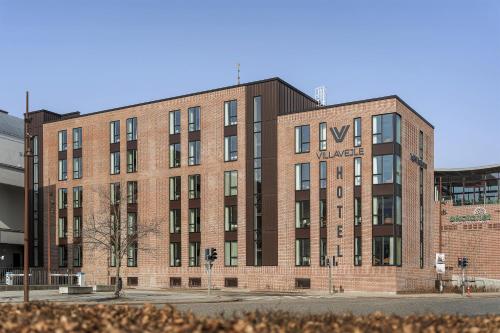 a large brick building on a city street at Villavejle Hotel, BW Signature Collection in Vejle