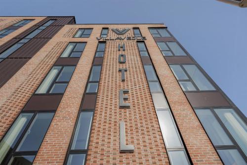 a tall brick building with a clock on it at Villavejle Hotel, BW Signature Collection in Vejle