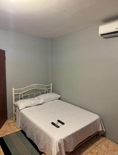 a bedroom with a bed with two slippers on it at Triple K Complex in Kelly Village