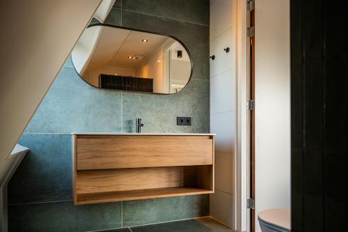 a bathroom with a sink and a mirror at Hotel Biedeboom in 's-Heer-Hendrikskinderen