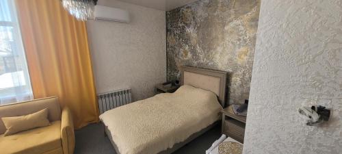 a small bedroom with a bed and a window at Антарес Отель in Shemonaīkha