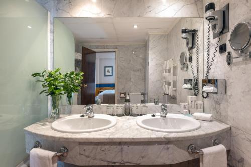 a bathroom with two sinks and a large mirror at Agumar Atocha in Madrid