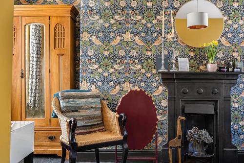 a living room with a chair and a fireplace at One Drake Road Hotel in Tavistock