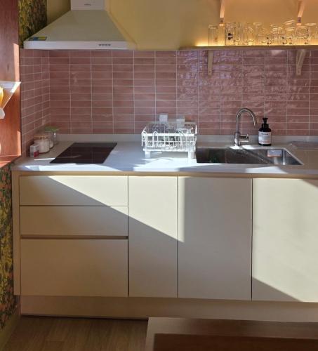 a kitchen with white cabinets and a sink at SoSi Stay in Seoul