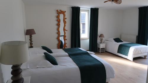 a bedroom with two beds and a lamp at Entre pierre & vigne in Arrentières
