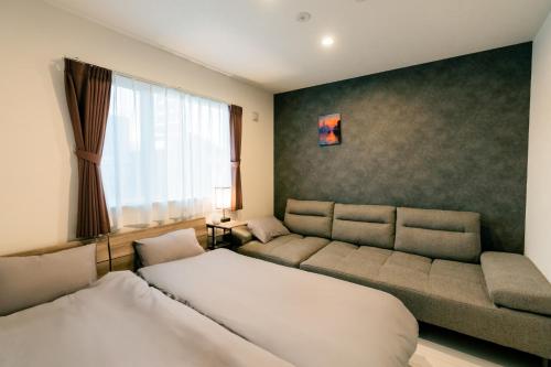 a living room with a couch and a bed at ステラガーデン in Kami-furano
