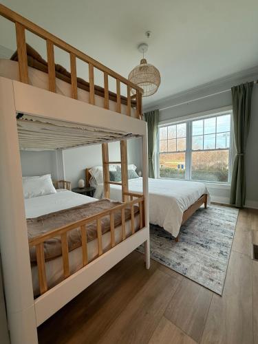 a bedroom with two bunk beds and a large window at The Cliffside Resort Condominiums in Greenport