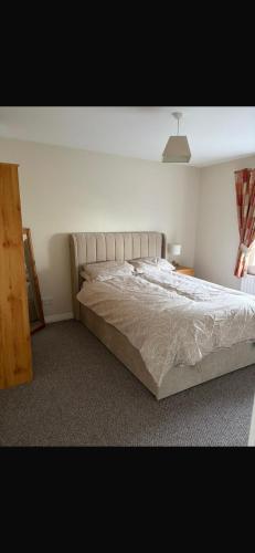 a bedroom with a large bed in a room at Ballycastle, Strand Cottages Modern Home in Ballycastle