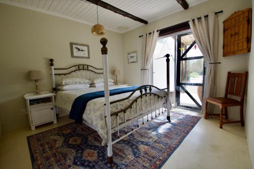 a bedroom with a bed and a door to a patio at Featherwood Cottage in Malgas