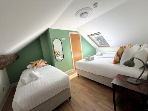 two beds in a room with green and white at Westport Rooms in Westport