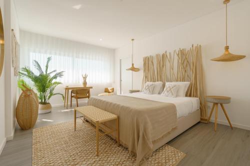 a bedroom with a large bed and a table at Chill Villa - Signature by Paradise Portugal in Mariquiteira