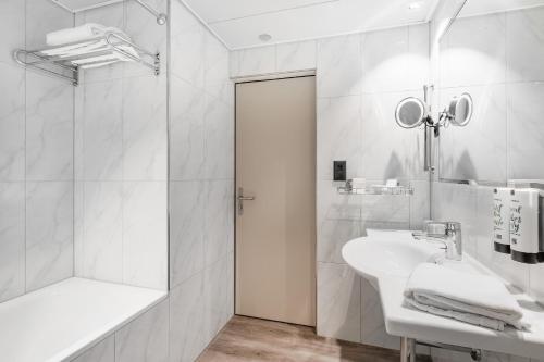 biała łazienka z umywalką i prysznicem w obiekcie Hotel Linde - 24h Self Check-in w mieście Baden