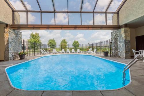 einen Pool mit Stühlen in der Unterkunft Days Inn by Wyndham Maumee/Toledo in Maumee