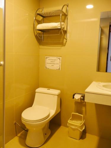 a yellow bathroom with a toilet and a sink at Casona Urinsaya Qolca in Chivay