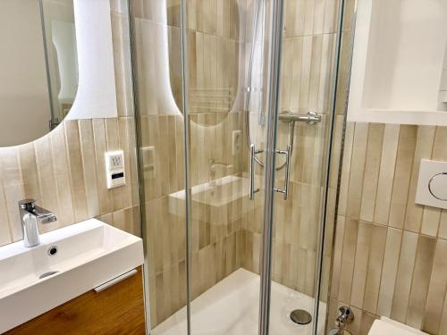 a shower with a glass door next to a sink at Seeluft in Westerland