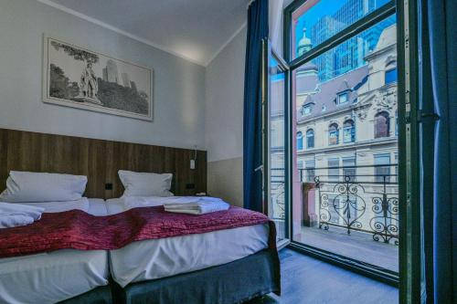 a bedroom with a bed and a large window at Ramada by Wyndham Frankfurt Central Station in Frankfurt