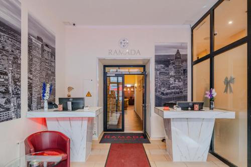 a shop with a red chair and a sign that reads ramada at Ramada by Wyndham Frankfurt Central Station in Frankfurt