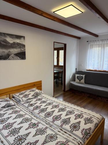 a bedroom with a bed and a couch at Pokoje gościnne Kozica in Zakopane
