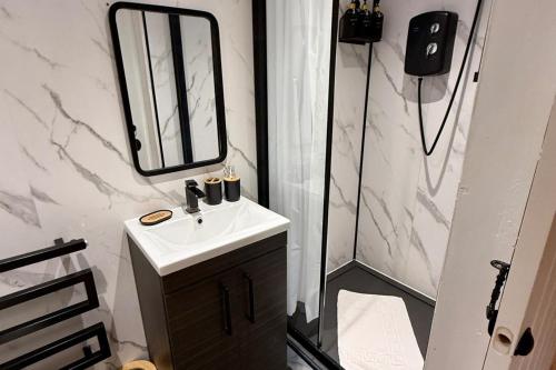 a bathroom with a sink and a mirror at 1 Bed Flat - Sleeps 5 - Pet friendly - Parking in South Shields