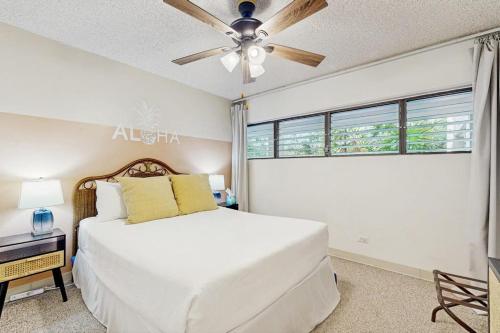 a bedroom with a white bed and a ceiling fan at Kalanikai #112 in Kailua-Kona