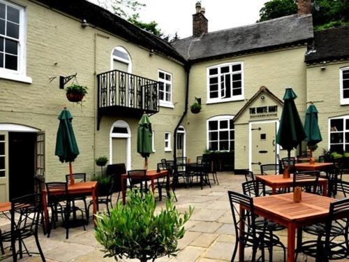 an outdoor patio with tables and chairs and umbrellas at White Hart Cafe Bar & Bistro in Ironbridge