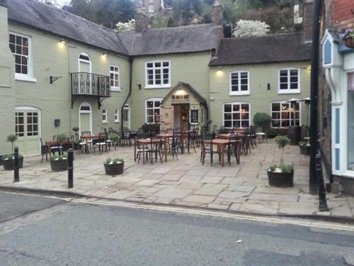 a patio with tables and chairs in front of a building at White Hart Cafe Bar & Bistro in Ironbridge