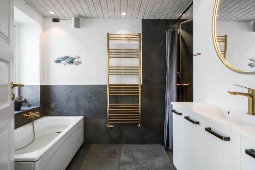 a bathroom with a tub and a shower and a sink at 266-Harboore-Strandvejen-177-A in Harboør