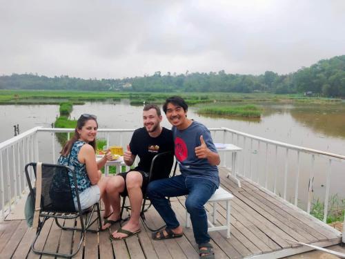 a group of people sitting at a table on a deck at Son Home Garden in Hue