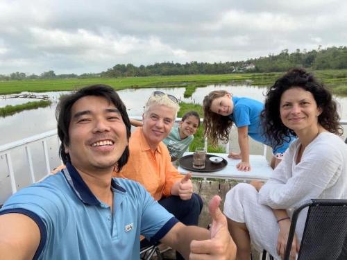 a group of people sitting around a table with a cake at Son Home Garden in Hue