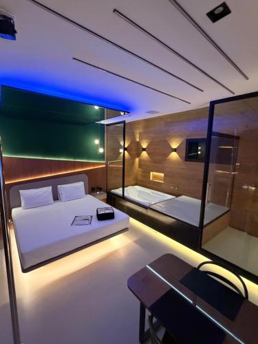 a bedroom with two beds and a table in a room at Ouro Motel in Sepetiba