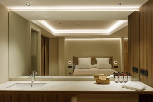 a bathroom with a sink and a large mirror at Aparthotel Mariano Cubi Barcelona in Barcelona
