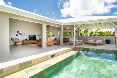 a villa with a swimming pool and a living room at Villa Joséphine in Grand-Bourg