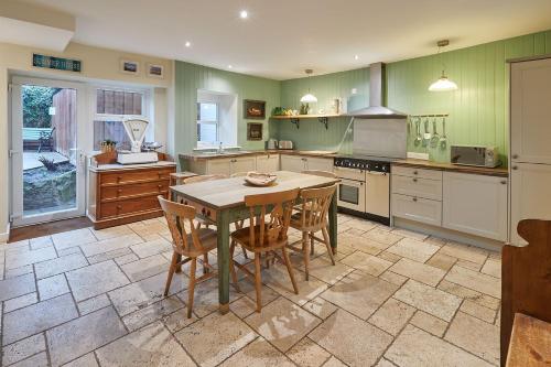 a large kitchen with a table and chairs in it at Church Cottage by Coast & Country Stays in Beadnell