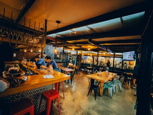 a restaurant with wooden tables and people sitting at them at Viajero San José Hostel in San José
