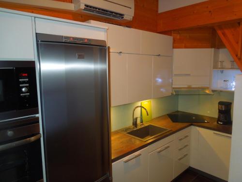 uma cozinha com um frigorífico de aço inoxidável e um lavatório em Aaria Apartment em Tahkovuori