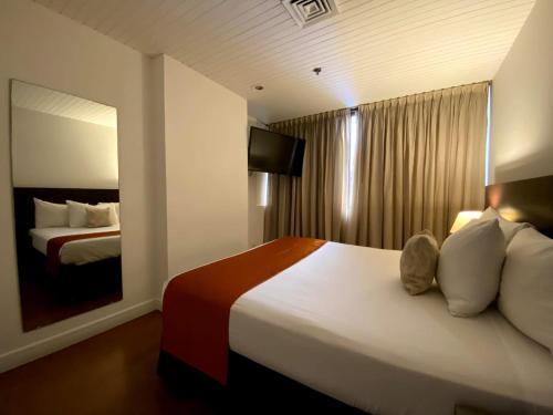 a hotel room with a bed and a television at Hotel CCT Caracas in Caracas