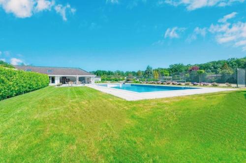 a large yard with a swimming pool and a house at NOFLIK, een gezellig chalet met een fraaie en rustige ligging in Stegeren