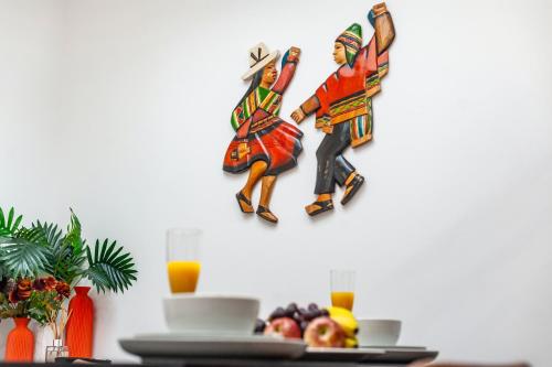 a wall with two statues of two people on it at Tambo Apartments in London