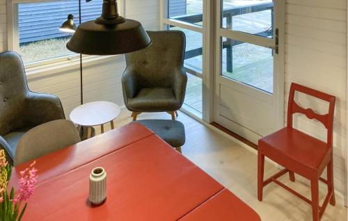 a living room with a table and chairs and a lamp at 1 Bedroom Beautiful Home In Nexø in Neksø