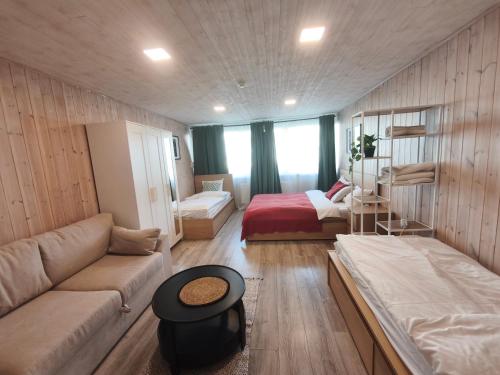 a living room with a couch and a bed at City Center Hostel in Mažeikiai