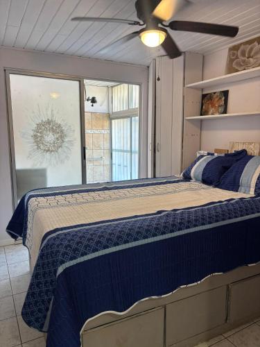 a bedroom with a large bed with a blue comforter at Hilltop Candy in San Isidro de El General