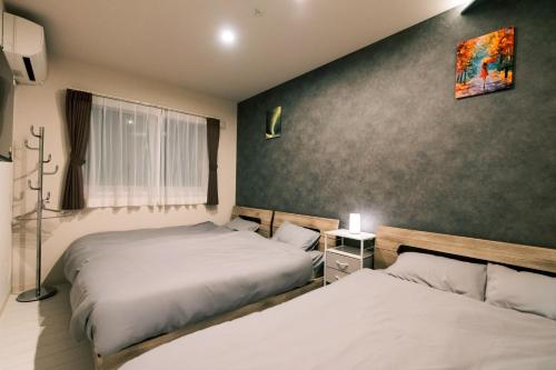 a bedroom with two beds and a window at ララリカ in Kami-furano