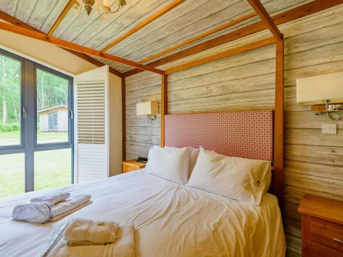a bedroom with a large bed with a wooden wall at 2 Bed in Newark oc-88427 in Walesby