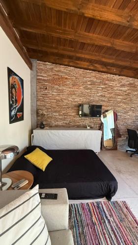 a bedroom with a bed and a brick wall at Florida Private loft, shared garden pool in Florida
