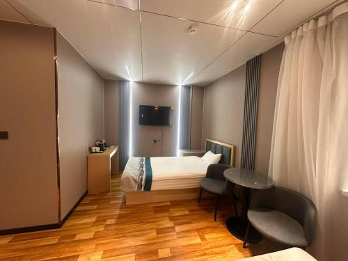 a hotel room with a bed and a table at Mandala Hotel Erdenet in Erdenet