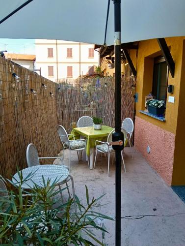 a patio with a table and chairs and an umbrella at LAKE COMO BORGO VIGNOLA - Cozy Apartment in a Charming Village in Cremia