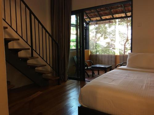 a bedroom with a bed and a staircase with a window at Spices Hotel in George Town