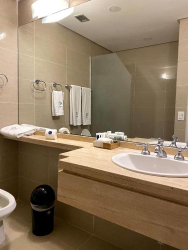 a bathroom with a sink and a mirror and a toilet at Hotel CCT Caracas in Caracas