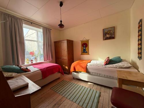 a bedroom with two beds and a window at Solkot Cottage Homestay in Reykjavík